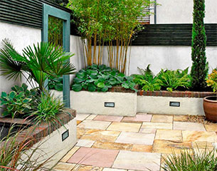 Dublin garden design of a small courtyard with sandstone paving and mirror.