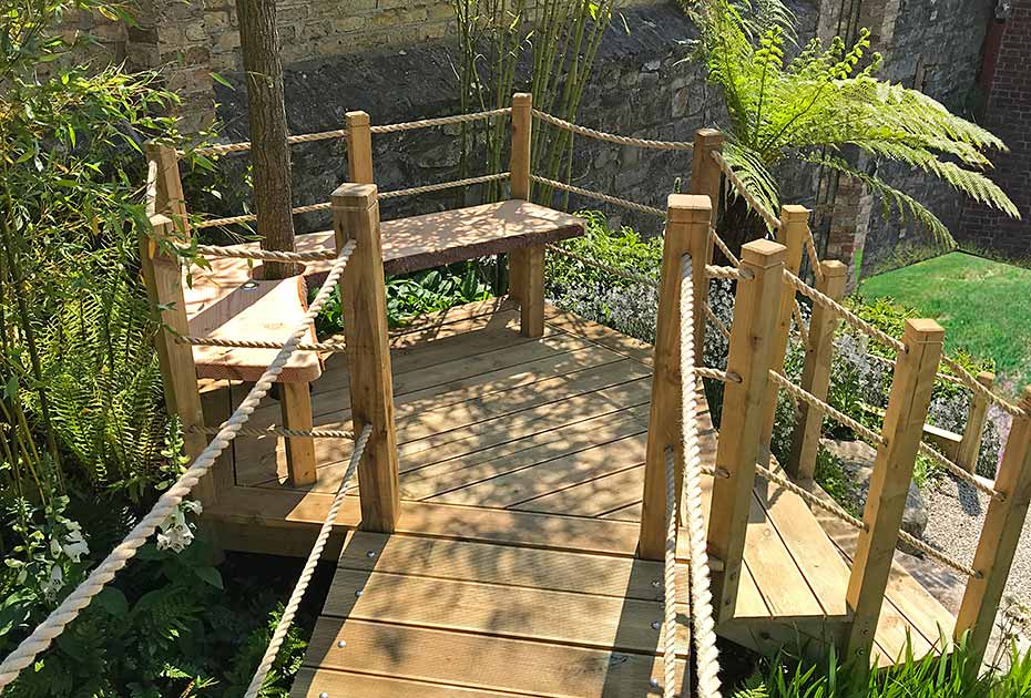 Wooden stairs lead you to a custom-built bench, on route to a beautifully designed treehouse, all within a small garden space.